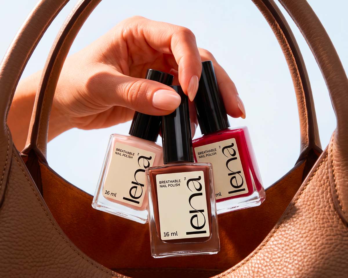 Three bottles of Lena nail polish held in a person's hand, suspended inside a large tan textured handbag against a pale blue sky.