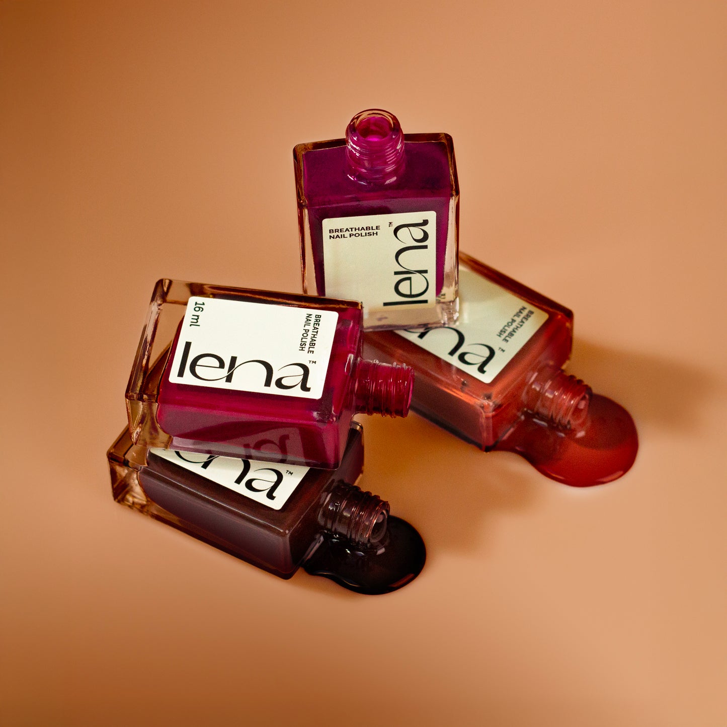 Four LENA breathable halal-friendly nail polish bottles in warm autumn shades of burgundy and brown, displayed on a soft beige background.
